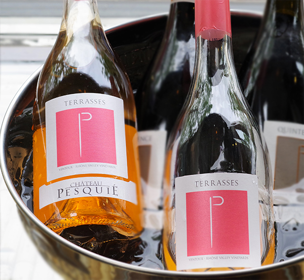 Four bottles of Terrasses Ventoux Rosé sit in a silver metal ice bucket, two behind, two in front. The bottle in the foreground to the right is almost empty, while the others are full.